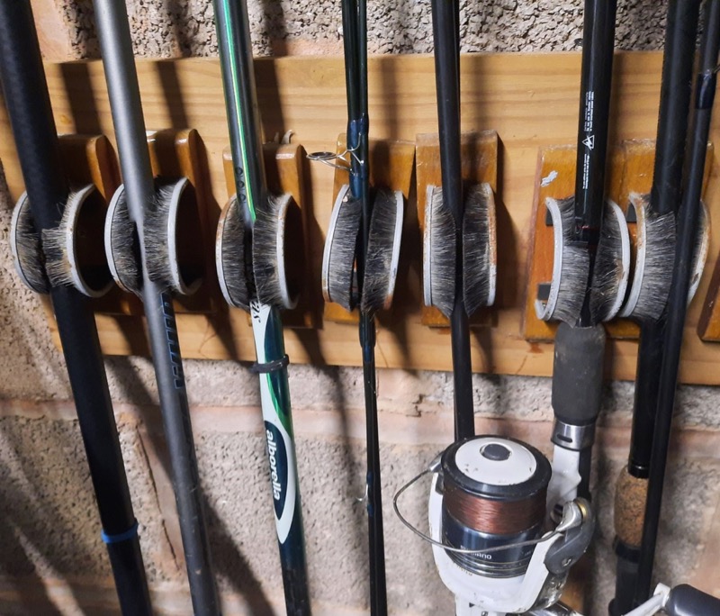 Fishing rods lined up on a wall rack