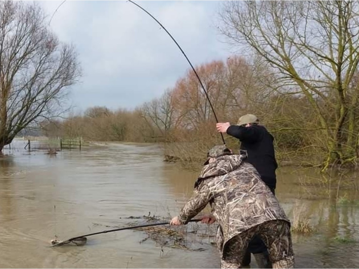 Landing a barbel in the flood. Always helps to have a friend...